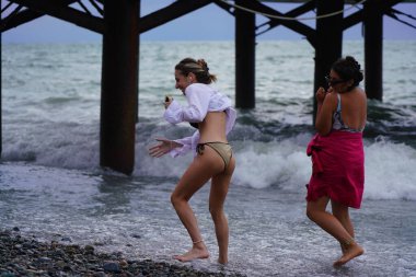 Batumi, Gürcistan - 11 Ağustos 2021: Fırtına sırasında deniz kıyısındaki kızlar