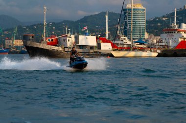 Batumi, Gürcistan - 24 Ağustos 2021: Erkekler denizde jet ski sürüyor