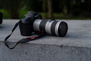 Batumi, Georgia - 19 Eylül 2021: 70-200 mm mercekli Canon kamera bir bankta yatıyor
