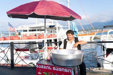 Batumi, Georgia - 19 Eylül 2021: Bir adam pamuk helva satıyor