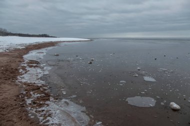 Donmuş denizin karlı kıyısı. Güzel doğa. Bulutlu kış günü.