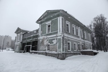 Karda terk edilmiş eski bir malikane. Kış günü. Terk edilmiş eski bir bina. Hava bulutlu. Gri kış günü.