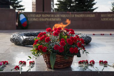 Sonsuz ateşin yanında bir çiçek çelengi. Zafer Günü 'nün anısına.