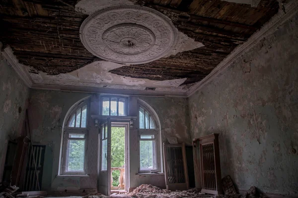 A beautiful room with shabby walls in an old abandoned house. Abandoned haunted manor. Ancient architecture and interiors.