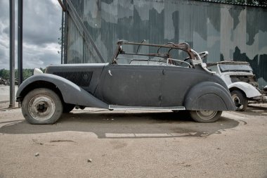 Terk edilmiş araba mezarlığındaki eski paslı araba. Eski, paslı bir araba. Araba mezarlığı..