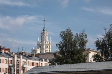Evlerin arkasında kulesi olan güzel eski bir gökdelen görülebilir. Eski Moskova 'nın şehir manzarası. Kulesi olan yüksek bir bina. Eski evler.