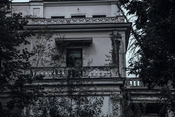 stock image Scary abandoned manor in a dark forest. Beautiful architecture. Old haunted abandoned house with ragged walls. A mystical abandoned mansion.