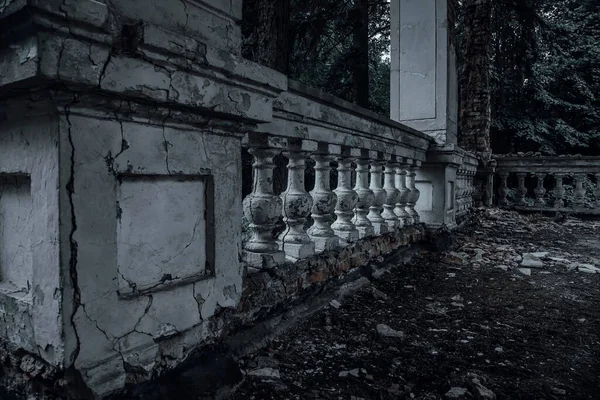 Old shabby columns in an abandoned manor. Scary haunted house. The ancient architecture of an abandoned house.