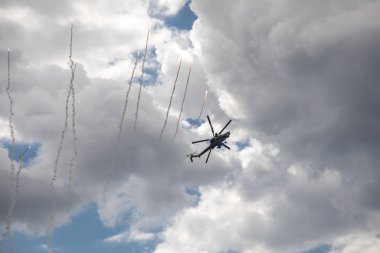 Bulutlu gökyüzünün arka planına karşı savaş helikopteri. Bulutlu gökyüzü. Güzel askeri uçak..