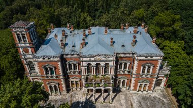 Ormanda terk edilmiş güzel bir malikane duruyor. Yeşil ağaçlar. Eski güzel mimari. Terk edilmiş eski kırmızı tuğla konak.