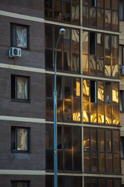 Evlerin pencerelerinde yaz günbatımının yansımaları.