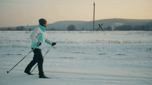 Teenager learning how to ski in the blue sky ant mountains background — Stock Video