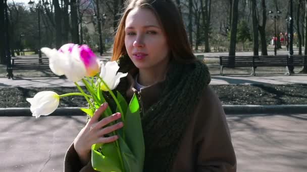 Woman standing in the park and holding bouquet of white — Stock Video