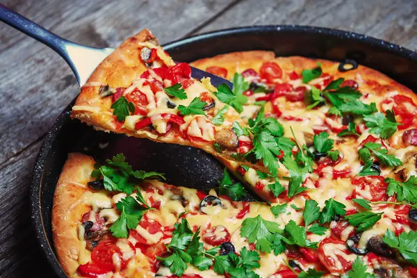 Tahta masada servis edilen lezzetli taze pizza.