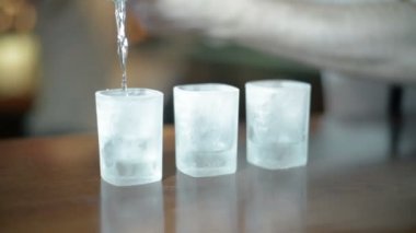 Barmen eline parlak zemin üzerine gözlük ile dökülen şişe içecek