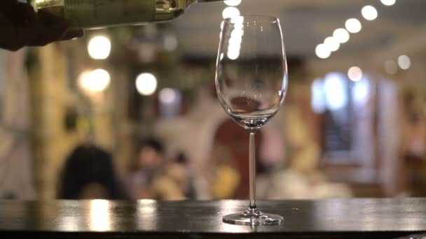 Крупный план вина, наливающего вино в бокал на белом фоне — стоковое видео