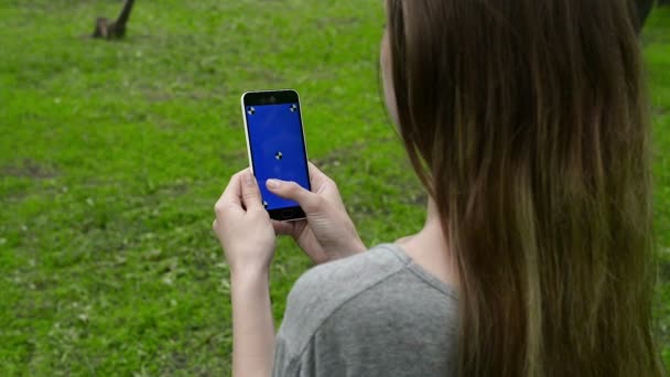 Chica tocando un teléfono inteligente en la pantalla verde con marcador — Vídeo de stock