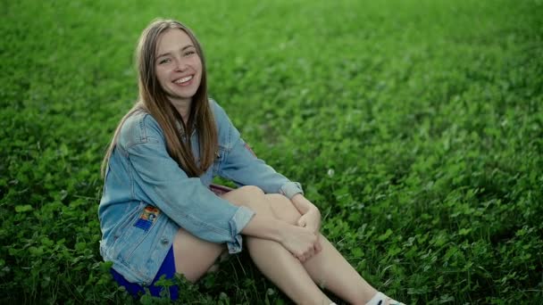 Belle femme assise à l'extérieur et souriante — Video