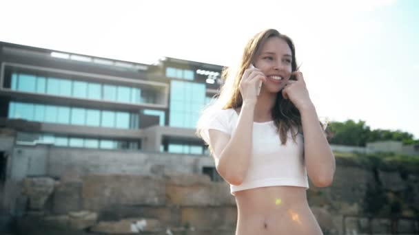 Güzel bir ev, bir arka plan ile telefonda konuşan kız — Stok video