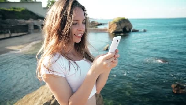Smartphone γυναίκα sms γραπτών μηνυμάτων χρησιμοποιώντας app στο smart phone στο παραλία ηλιοβασίλεμα. Αναμιγνύεται — Αρχείο Βίντεο