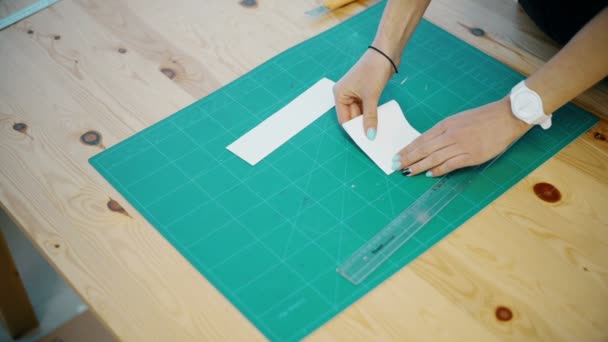 Frau schneidet Papier auf den Tisch — Stockvideo