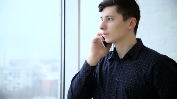 Деловой человек покидает офис и отвечает на телефонный звонок — стоковое видео