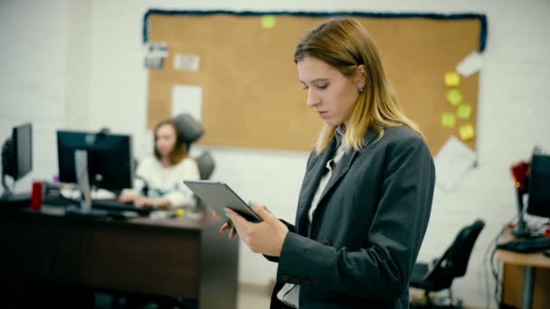 Businesswoman standing in corridor with tablet — Stock Video