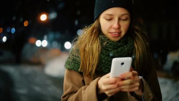 Mujer utilizar el teléfono móvil en la ciudad por la noche — Vídeos de Stock