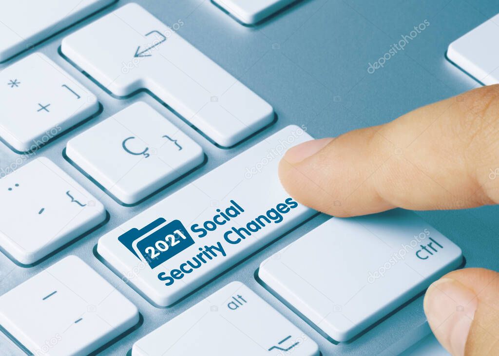 2021 Social Security Changes Written on Blue Key of Metallic Keyboard. Finger pressing key.
