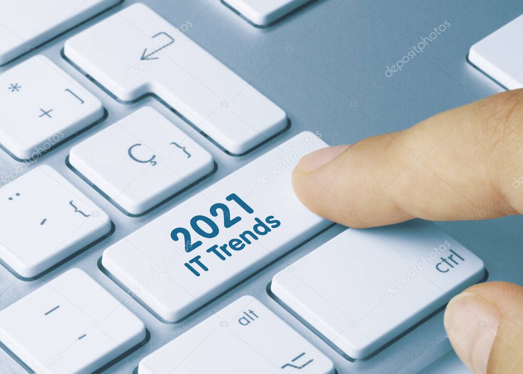 2021 IT Trends Written on Blue Key of Metallic Keyboard. Finger pressing key.