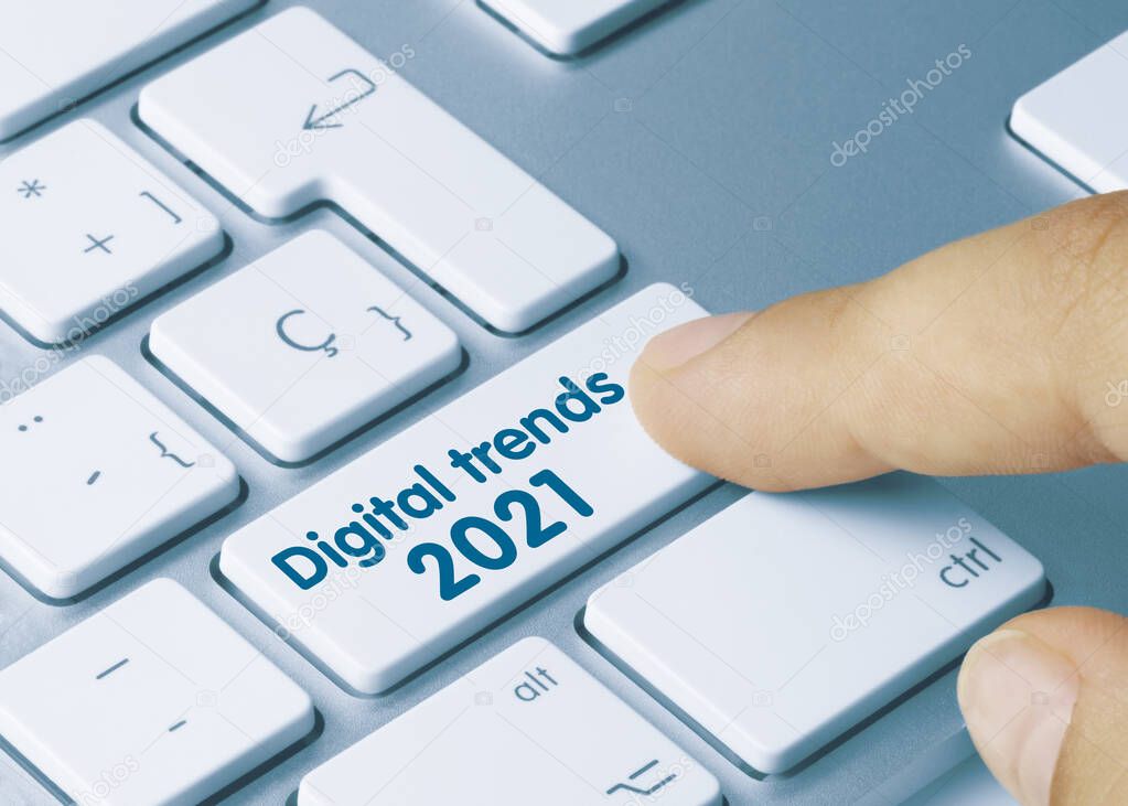 Digital trends 2021 Written on Blue Key of Metallic Keyboard. Finger pressing key.