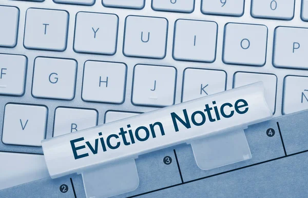 Eviction Notice Written on Blue Key of Metallic Keyboard. Finger pressing key.