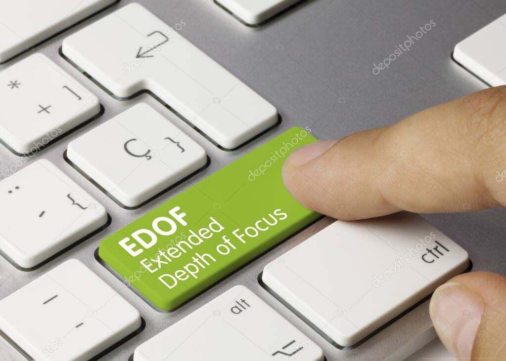 EDOF Extended Depth of Focus Written on Green Key of Metallic Keyboard. Finger pressing key.