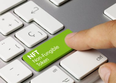 Metalik Klavyenin Yeşil Anahtarı Üzerine NFT İade Edilemez Token Yazısı. Parmak tuşuna bas.