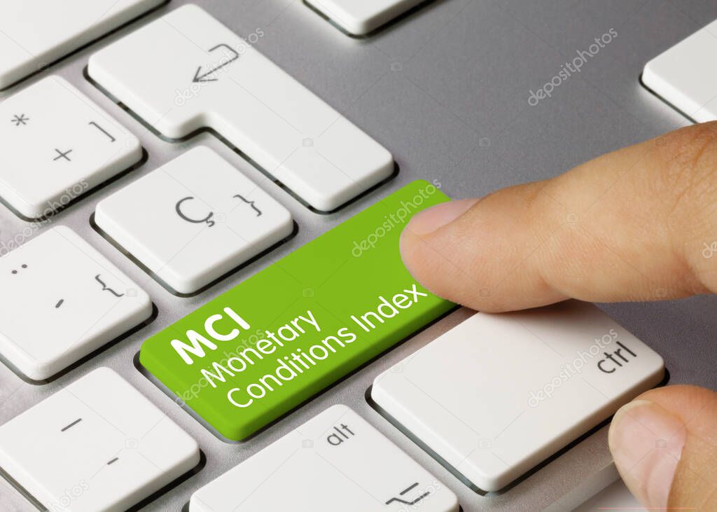 MCI Monetary Conditions Index Written on Green Key of Metallic Keyboard. Finger pressing key.