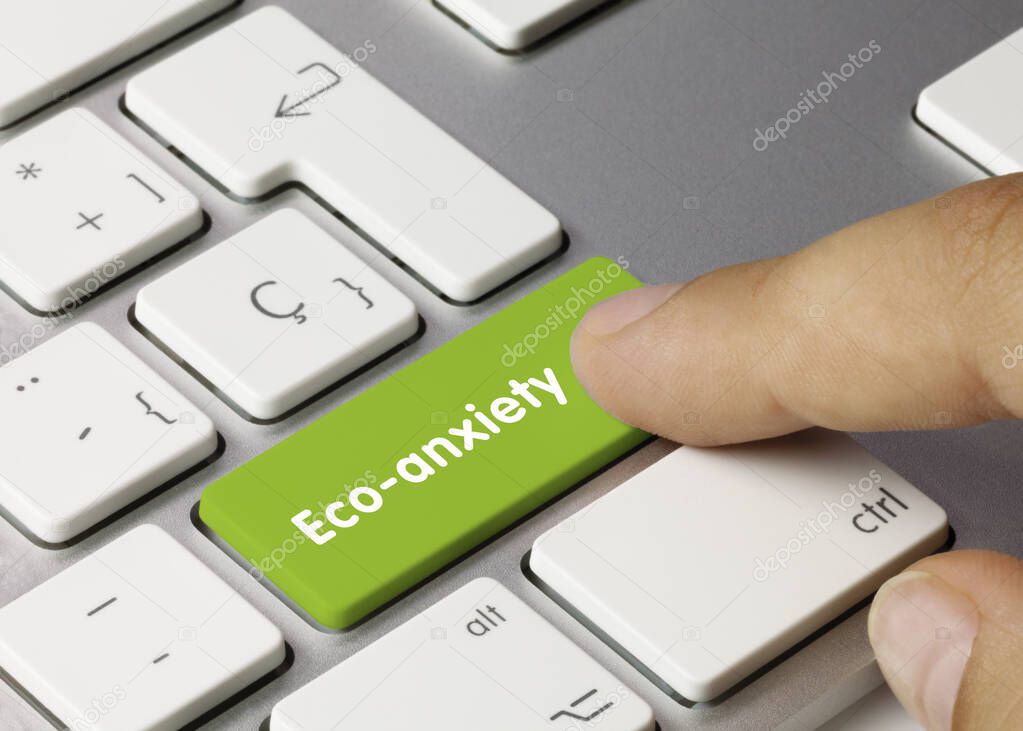 Eco-anxiety Written on Green Key of Metallic Keyboard. Finger pressing key.