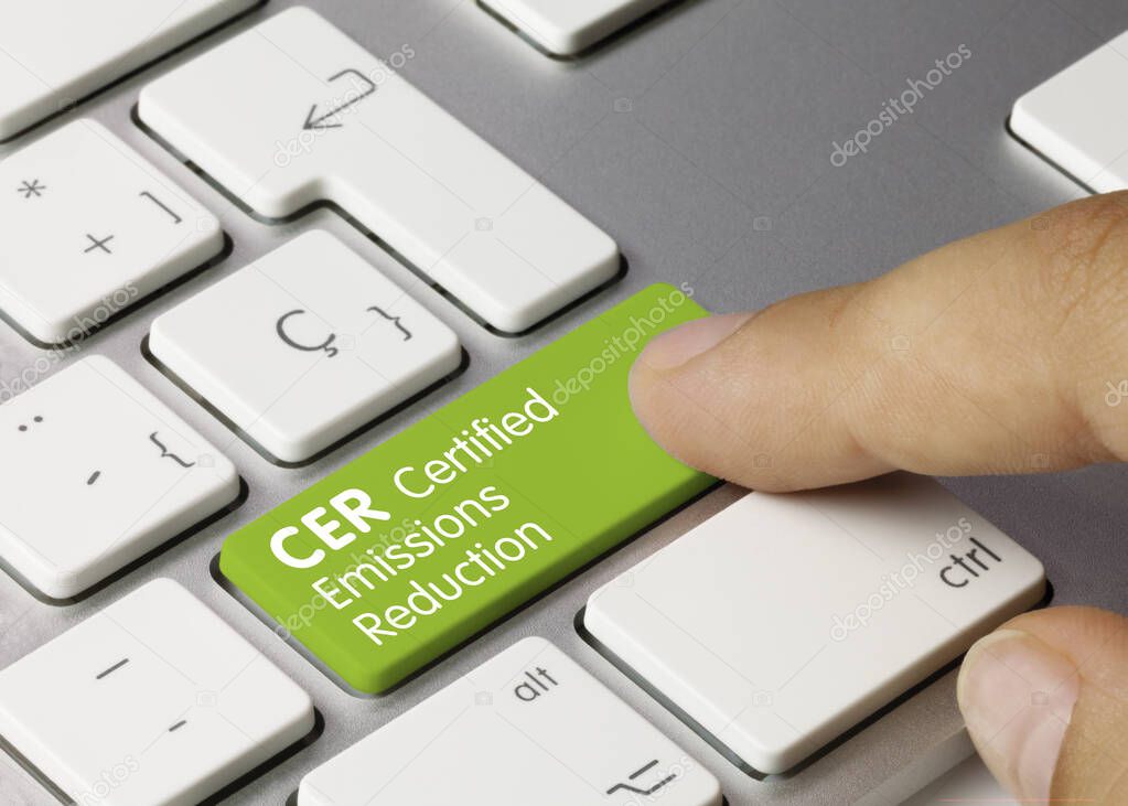 CER Certified emissions reduction Written on Green Key of Metallic Keyboard. Finger pressing key.
