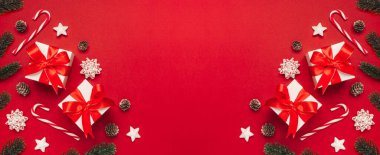 Mutlu Noeller ve mutlu bayramlar tebrik kartı arkaplanı ortasında da telif alanı var. Kırmızı arka plan manzaralı Noel hediyeleri ve dekor. Düz yatış tarzında kış xmas tatil teması