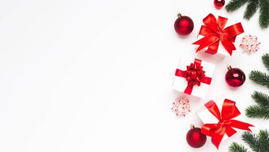 Noel tebrik kartı arkaplanı sol tarafta. Beyaz arka planda Noel hediyeleri ve kırmızı dekor. Kış Xmas bayramı teması. Düzleştirme biçimi