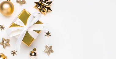 Mutlu Noeller ve mutlu bayramlar tebrik kartı geçmişi ve telif alanı sağ tarafta. Altın Noel hediyesi ve beyaz arka plan manzaralı dekor. Düz yatış tarzında kış xmas tatil teması