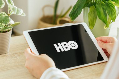 VALENCIA, İspanya - Ekim 2020 HBO uygulaması bir tablet ekranda. Genç Kız, Talep üzerine TV programları, Belgesel, Seriler ve Filmler 'i oturma odasında tablet ile izliyor.