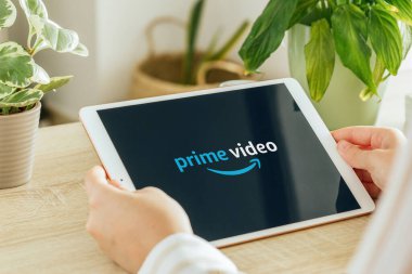 VALENCIA, İspanya - Ekim 2020: Tablet ekranda Amazon Prime Video uygulaması. Genç Kız, Talep üzerine TV programları, Belgesel, Seriler ve Filmler 'i oturma odasında tablet ile izliyor.