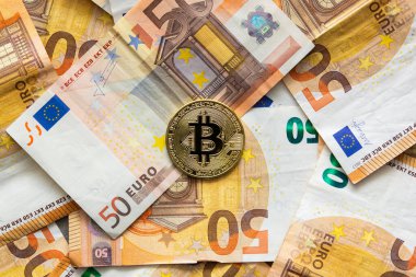 50 avroluk banknotların arka planındaki bir bitcoin 'in genel görünümü. Yeni para olarak Bitcoin, kripto para piyasası ve merkezi olmayan finans kavramı