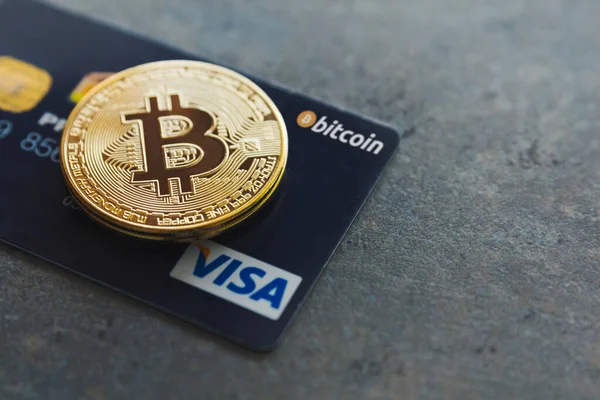 Valencia, İspanya - Nisan 2021: Bir bitcoin ve dokulu bir arka planda bir kredi kartı. Dünyada 40 milyondan fazla yerde istediğin yerde kriptoyla ödeme yapabilirsin. Bitcoin yeni para gibi