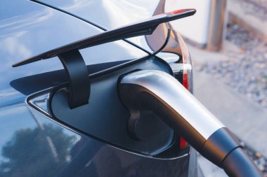 Şarj istasyonunda şarj kablosu pili takılı EV Car veya elektrikli araç. Otomobil ve Çevre dostu alternatif enerji kavramının geleceği