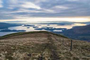 Gün doğumundan sonraki bulutlu bir sabah Beinn Dubh 'ın Lomond Gölü üzerindeki görüntüsü.