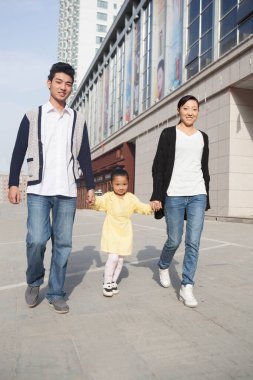 Alışverişe gidecek üç kişilik mutlu bir aile.