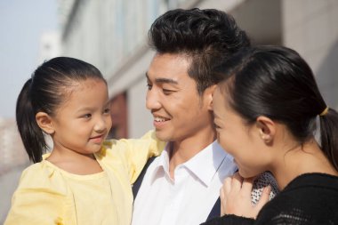 Alışverişe gidecek üç kişilik mutlu bir aile.