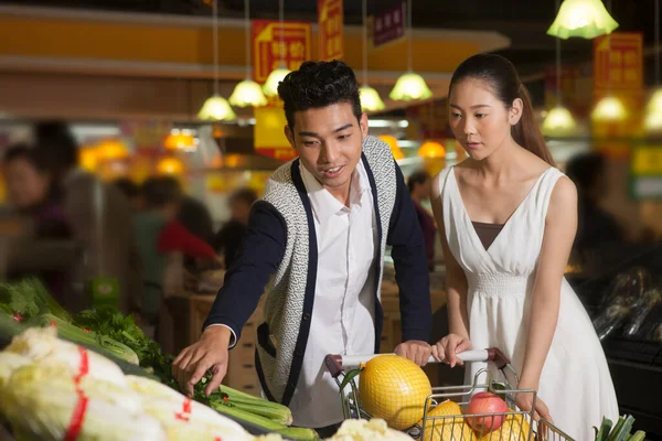 Una giovane coppia al supermercato a fare shopping — Foto Stock