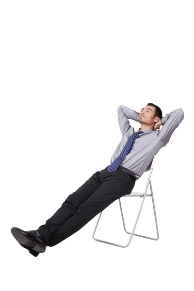 Um jovem homem de negócios alegre sentado postura — Fotografia de Stock